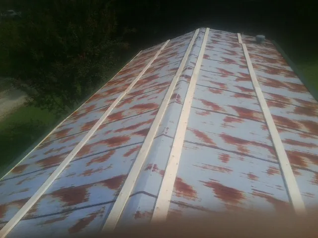 Rusted metal roof panels with new wood purlins before replacement — Storm Damage Roof Repair in Hebron by Roofing Brothers
